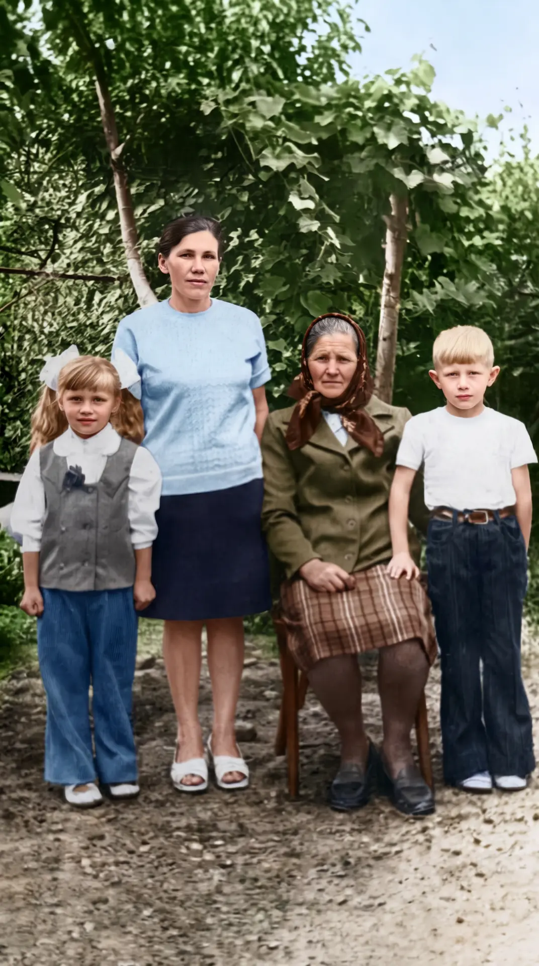Restored and colourised family portrait of two children, a mother and a grandmother in a garden